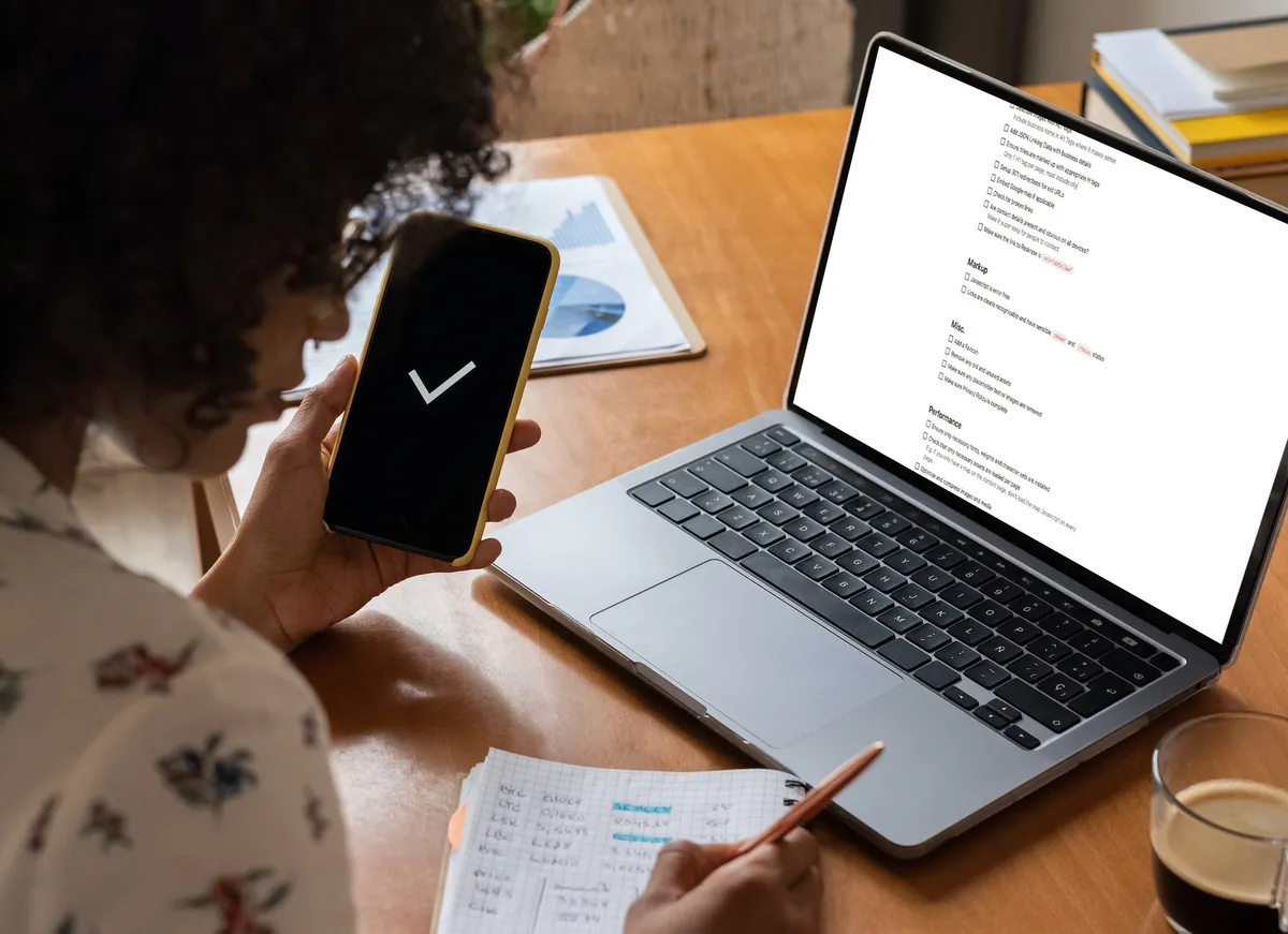 Curly haired women working on a checklist in front of a computer