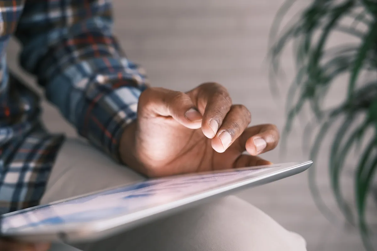Young man reading report on his tablet